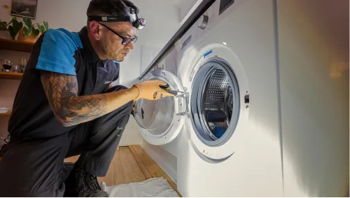 British gas engineer looking at washing machine